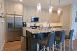 The kitchen boasts high-end finishes, stainless steel appliances, and a spacious island.