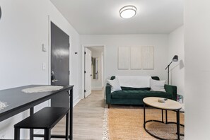 Bright, airy living room with large windows, modern design, and  comfy seats.