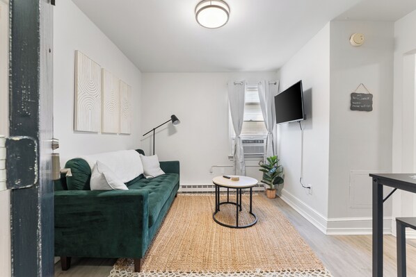 This living area is bright with natural light, a comfy sofa, and modern décor.