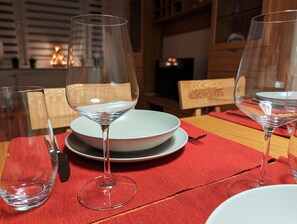 Gedeckter Tisch mit stilvollem Geschirr, Besteck und GlÀsern sowie Schwibbogen