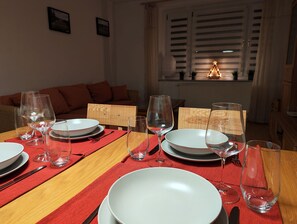 Gedeckter Tisch mit stilvollem Geschirr, Besteck und GlÀsern sowie Schwibbogen