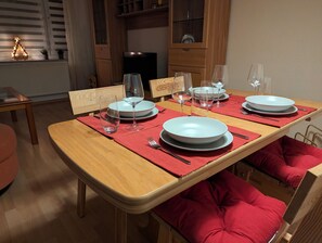 Gedeckter Tisch mit stilvollem Geschirr, Besteck und GlÀsern sowie Schwibbogen