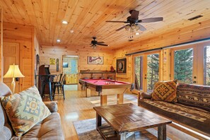 Rustic game room with pool table, arcade, and cozy seating for endless fun!