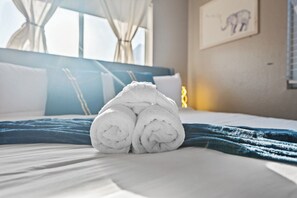 Modern bedroom with king bed, neutral tones, TV storage and natural light