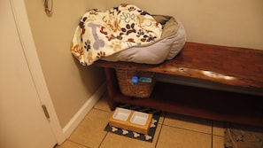 The doggy corner offers a cozy bed and various amenities, including toys, treats, bowls, leash, and clean-up bags, creating a dedicated space for your furry friends to feel right at home.