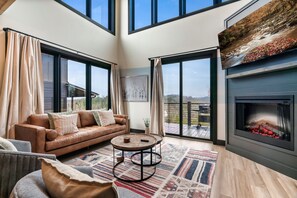 Living room with Double height windows that opens to nature. Grill provided.