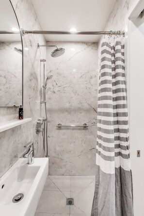 spacious shower stall with rainfall shower head and removable shower arm for a spa like shower.