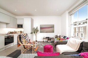 Step into this cozy and well-arranged living room, featuring a comfortable couch that invites relaxation. The couch is adorned with soft pillows, setting the stage for a perfect entertainment area.