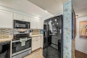 The fully equipped kitchen features granite countertops, updated cabinets & appliances, and has everything you need to prepare meals for family & friends.