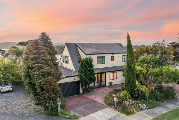 View of the house with the sun setting behind it.
