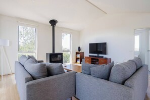 Gather in the inviting living room with a cosy fireplace, perfect for unwinding after a day of exploring.
