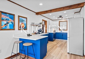 This modern kitchen is not only stylish with its bold blue accents but also fully equipped for all your cooking needs. From casual breakfasts to family feasts, this space makes every meal a treat.