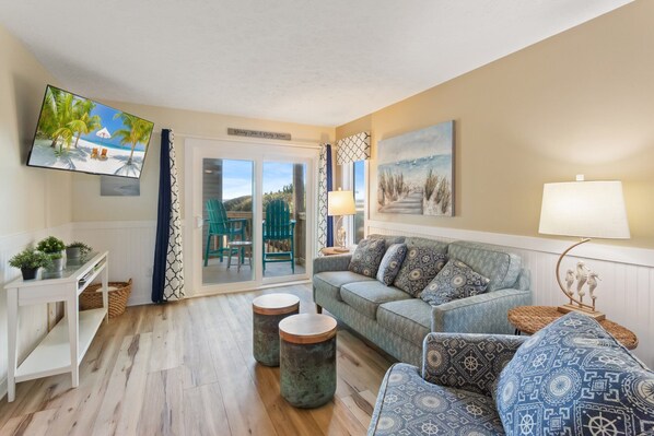 The Living Area features a flat-screen TV and access to the deck, perfect for enjoying those cool breezes right off the ocean.