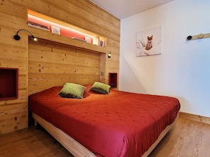 Comfortable sleeping area with plush bedding and warm wood tones, providing a restful retreat in the heart of the mountains.