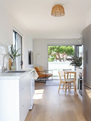 The modern kitchen boasts sleek countertops & Contemporary appliances.