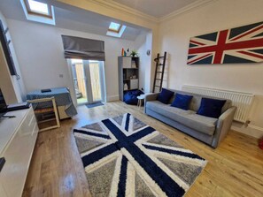 Living area with sofa bed and fold out dining table and smart TV