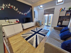 Living area with sofa bed and fold out dining table and smart TV