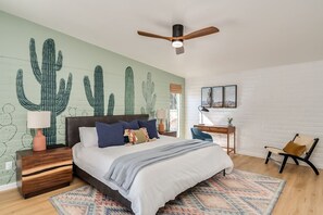 Unwind in our serene primary bedroom featuring plush king bed, soothing ceiling fan, and all the essentials for a restful night: blackout shades, bedside lamps, charging dock, and a sound machine for ultimate relaxation. Located in in the main house.