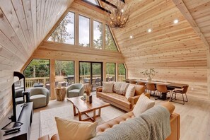 A living room complete with a smart Tv, plenty of seating room and adjacent to the huge outdoor patio and dinning area. 