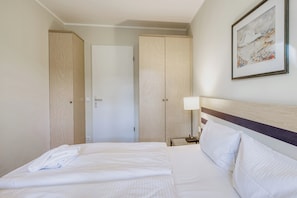 Ferienwohnung Ostseeanker in Zingst Schlafzimmer mit Doppelbett und Kleiderschränken