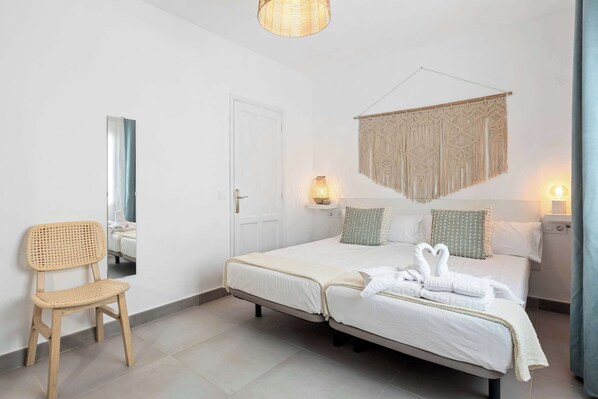 🛏️ Dormitorio principal en Los Cocoteros con cama doble y ventana que llena el espacio de luz natural canaria. Descanso perfecto después de explorar Lanzarote. ¡Tu refugio! 💫 Reserva ya