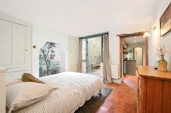 Stunning, arty bedroom with doors leading to both the private rear garden and the fully fitted kitchen & shower room
