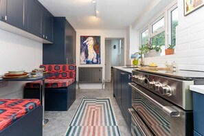 Contemporary eat-in kitchen with integrated appliances and plentiful storage.