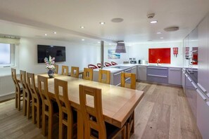 Stunning, fully equipped kitchen with dining table that seats 12 guests, and a breakfast bar.