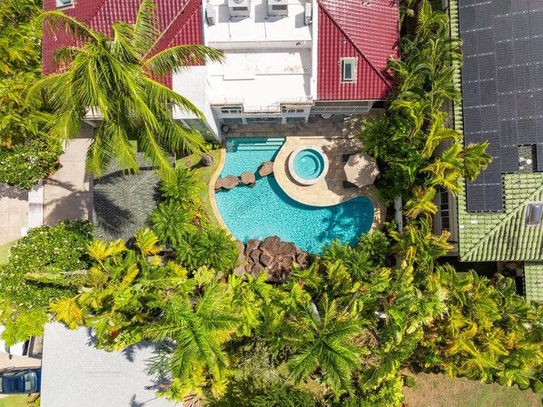 Aerial view of the lush pool area surrounded by tropical gardens, offering a serene, private oasis.
