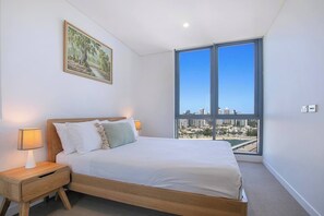 The primary bedroom boasts views over the water and skyline and comes with a queen-sized bed and ensuite bathroom.

