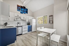 Full kitchen with a 4-person dining set & mountain views.