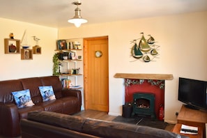 Living room area, with x2 leather sofas, electric fireplace and TV