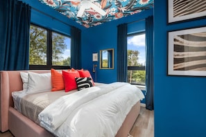 Bedroom #3: A serene retreat with a luxurious king-size bed and a unique flowery wallpaper on the ceiling, creating a peaceful atmosphere perfect for meditation before sleep.