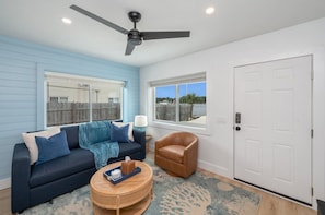 Living area with beautiful windows that let in plenty of natural light, creating a warm and welcoming atmosphere for your stay.
