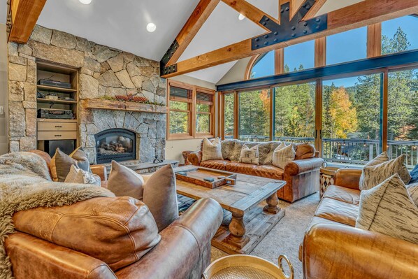 Living Room: 3 couches, sitting area with 4 chairs, wet bar with wine cooler, gas fireplace, 85” Smart TV, upper floor