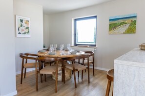 Gather around the beautiful wooden dining table, comfortably seating six guests in a warm and inviting setting.