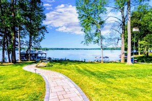 Charming pathway leading to a peaceful lakefront with a private dock and lush green surroundings