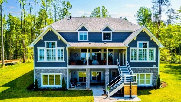 Spacious, modern cabin with a beautiful two-level deck and large windows, nestled in a lush, wooded setting
