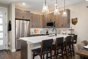 Fully Stocked Chefs Kitchen With An Island That Includes Bar Seating For 4 People