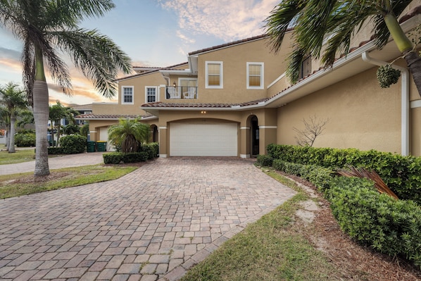 Stroll through a stunning Mediterranean-style walkway leading to your private garage retreat.