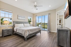 Wake up in style in this chic master's bedroom, featuring a wide window and sliding door opening to stunning balcony views