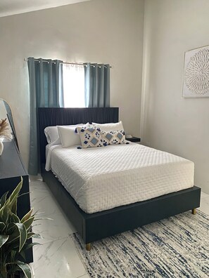 Plush Pillow Top Queen bed cladded in soft cotton sheets for a comfortable sleep
