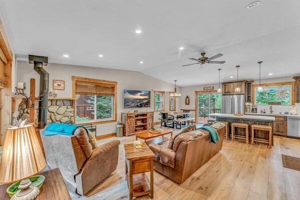 Main living space: Open layout, 3-cushion couch, 1 recliner, 65” Smart TV w/DVD player, wood-burning fireplace, 6-person dining table, well-equipped kitchen