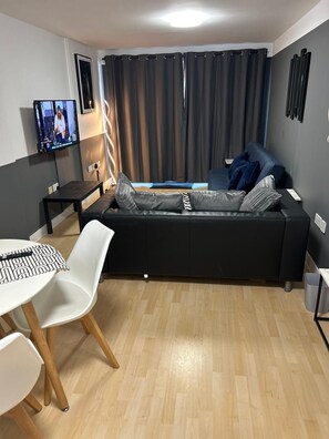 Relaxing living room with a comfy sofa and TV, perfect for unwinding after a day of exploration.