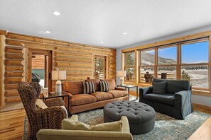 Living room featuring large windows for ample views, TV, and gas fireplace.