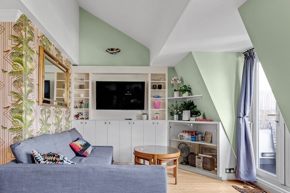 Open plan living room and kitchen with French doors opening onto the balcony. 