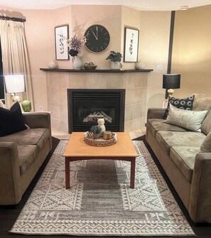 Cozy living room with two couches (one pull out) and a gas fireplace.