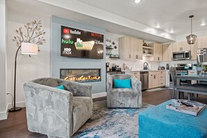 Large 65-inch Roku TV, fireplace and plush swivel chairs enhance personal conversations and TV viewing.