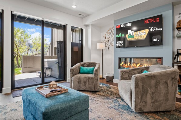 The living room has a large smart TV, electric fireplace, amazing views, and direct access to the deck.