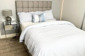 Spacious bedroom with large built-in wardrobe, work space and dressing mirror
